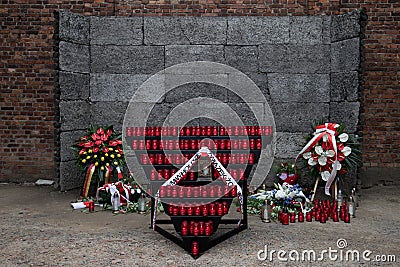 Flowers and candles by the Wall of Death, Auschwitz Editorial Stock Photo