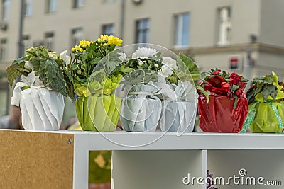 Flowers in decorated pots on shelf outdors Stock Photo