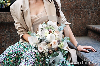 Flowers delivery. Faceless portrait of woman with receiving beautiful flowers bouquet from delivery outdoors Stock Photo