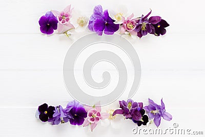 Flowers flat design. Floral frame violet , purple, pink white flowers. Template with copy space on white wooden board. Viola , Stock Photo