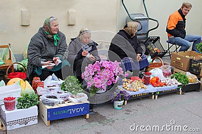 Elderly women sell Cosmos flowers and fruits at the Kalvariju market in the Old town of Vilnius, Lithuania Editorial Stock Photo