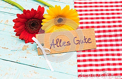 Flowers and gift card with german text, Alles Gute, means best wishes for Birthday or Anniversary Stock Photo