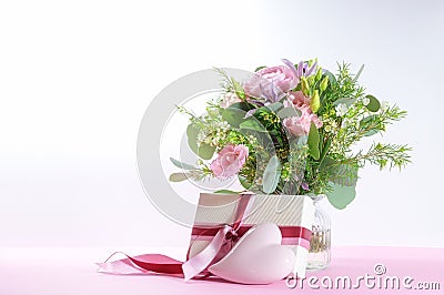 Flowers, gift and a light pink heart, romantic love symbol for holidays like Wedding, Valentines day, birthday or Mothers day, Stock Photo