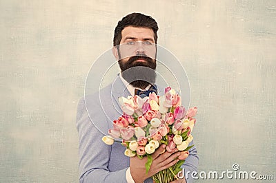 Flowers for her. Man bearded suit bow tie hold tulips bouquet. Gentleman making romantic surprise for her. Flowers Stock Photo