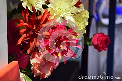 Flowers made of artificial materials in a pink bucket Stock Photo