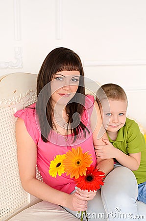 with flowers next to her son Mom Stock Photo