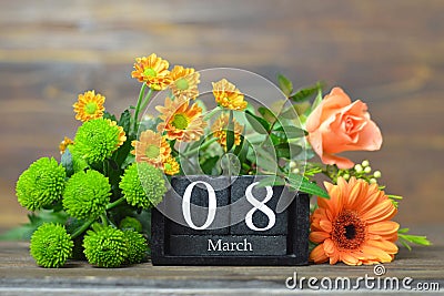 Flowers and wooden calendar with date of International Womens Day Stock Photo