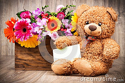 Flowers and a teddy bear Stock Photo