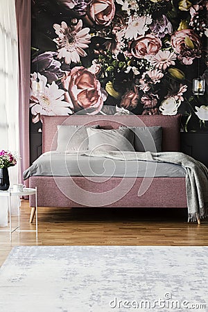 Flowers wallpaper in feminine pink bedroom interior with grey pi Stock Photo