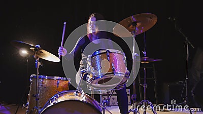 Flowing black hair - beauty girl plays drum rock at garage Stock Photo