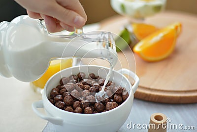 Flowing milk on cereal chocolate balls, chocolate flakes Stock Photo