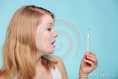 Flu. Sick girl with fever checking thermometer. Stock Photo