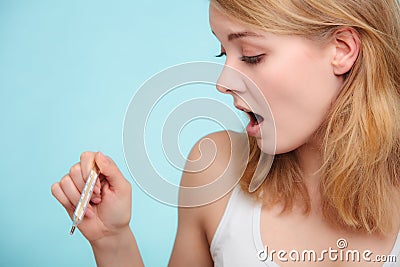 Flu. Sick girl with fever checking thermometer. Stock Photo