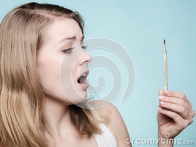 Flu. Sick girl with fever checking thermometer. Stock Photo