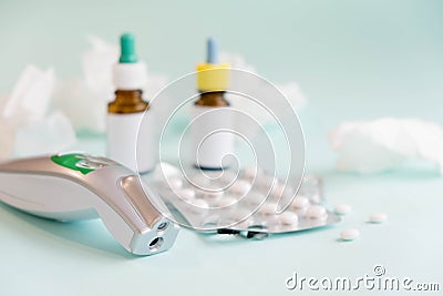 Flu treatments. Spray for the nose or a pill to treat colds and gripes. Glass Bottle with medicines and paper handkerchiefs on blu Stock Photo