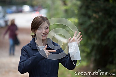 Flue and corona safety concept. Woman holding single use face mask, outdoors Stock Photo