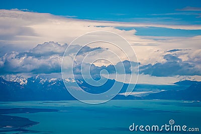 Fluffy clouds hover over the bay and the mountains. Shevelev. Stock Photo