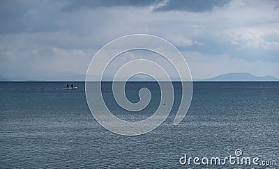 Fluffy grey clouds meet calm dark blue sea Stock Photo