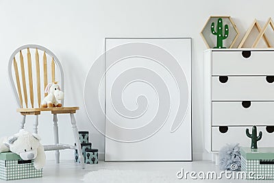 Fluffy toy placed on wooden chair in white baby room interior wi Stock Photo