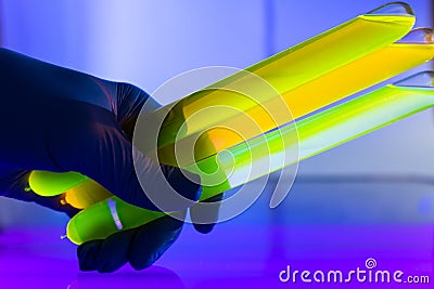 Fluorescein glowing in flask under ultraviolet light. Stock Photo