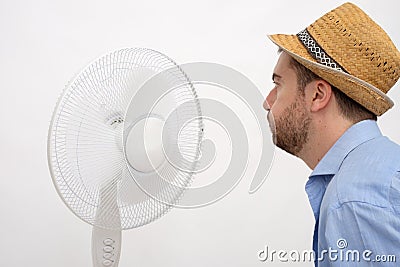 Flushed man feeling hot in front of a fan Stock Photo