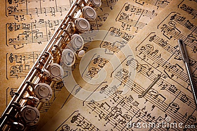 Flute with rod on old handwritten sheet music elevated view Stock Photo