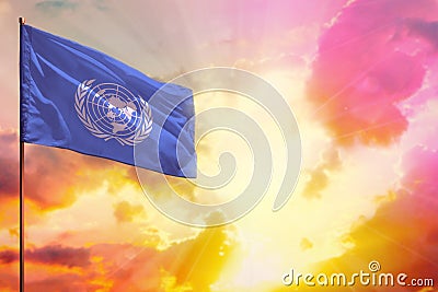Fluttering United Nations flag in top left corner mockup with the space for your text on beautiful colorful sunset or sunrise Editorial Stock Photo