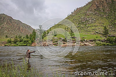 Fly fisherman casting a fly on a river in Mongolia during the summer, Moron, Mongolia Stock Photo