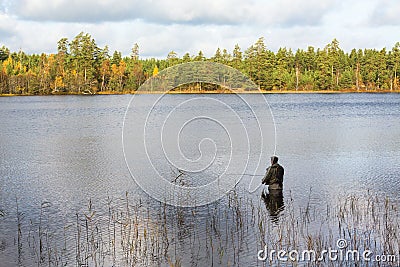 Fly fisherman standing in lake and fishing Editorial Stock Photo