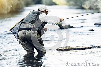 Fly fisherman using flyfishing rod. Stock Photo