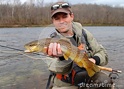 Fly fishing - fisherman holding fish (fish focus) Stock Photo