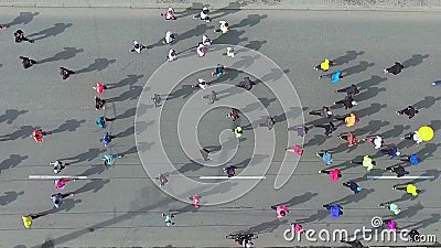 Flyg- överkant ner skott av folkmassan av löpare som kör under maraton på stadsvägen stock video Flyg- överkant ner skott av folkmassan av löpare som kör under maraton på stadsvägen stock video