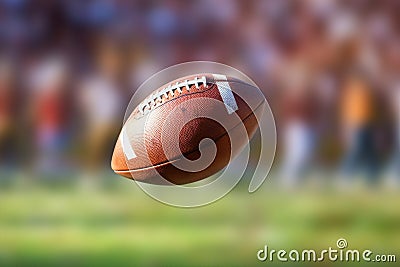 Flying American football ball with blurry stadium in background Stock Photo