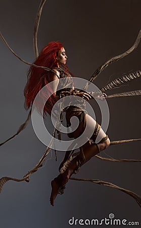 Flying beautiful red haired woman bounding by ropes Stock Photo