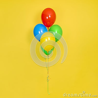 Flying bunch of Colorful Balloons isolated on yellow background. Party, gift, birthday, or celebration concept Stock Photo