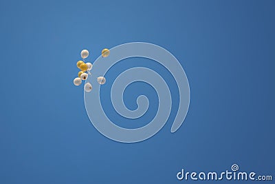 Flying bunch of yellow and white balls on a blue background background. Summer sunny day Stock Photo