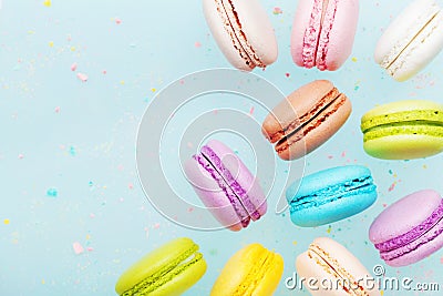 Flying cake macaron or macaroon on blue pastel background. Colorful almond cookies on dessert. Stock Photo