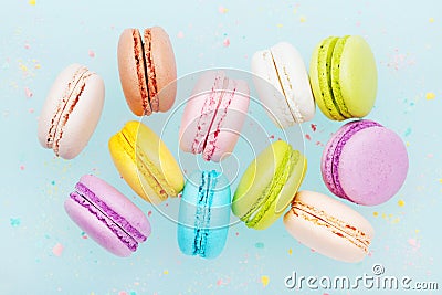 Flying cake macaron or macaroon on turquoise pastel background. Colorful almond cookies on dessert. Stock Photo