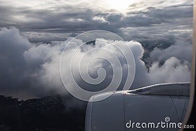 Flying through the clouds, below the earth, the sun shines through the clouds. Jet engine aircraft. Stock Photo