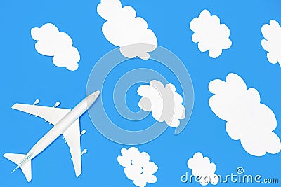 Flying through the clouds. Dreams of traveling, overcoming and success concept. Model passenger airplane and paper Stock Photo