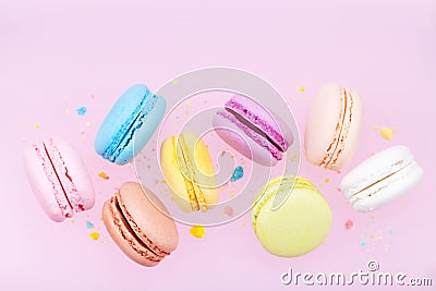 Flying colorful macaron or macaroon on pink pastel background. Stock Photo