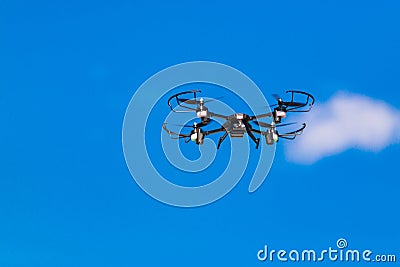 Flying drone or quad copter in clear blue sky Stock Photo