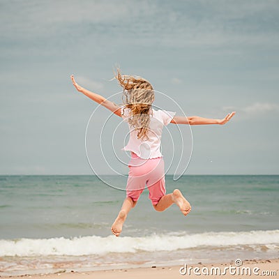 Flying jumping beach girl at blue sea shore Stock Photo