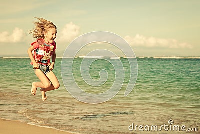 Flying jumping beach girl at blue sea shore Stock Photo