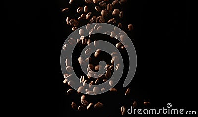 Flying roasted coffee grains on a black background Stock Photo