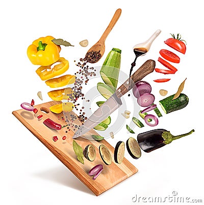 Flying slices of sliced vegetables are served on a wooden board Stock Photo
