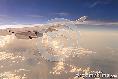 Flying into sunset sky and sea of clouds and Wing of airplane wi Stock Photo