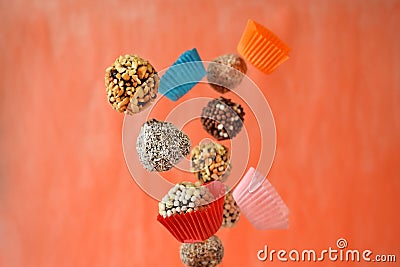 Flying sweets with different sprinkles and paper cups Stock Photo