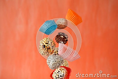 Flying sweets with different sprinkles and paper cups Stock Photo