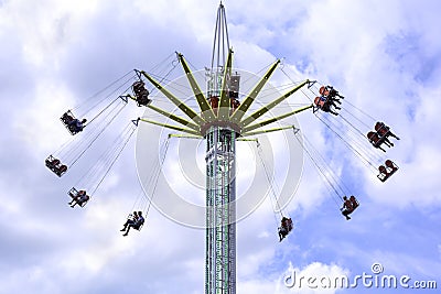 People enjoy a ride on a flying swing ride at an amusement park Editorial Stock Photo